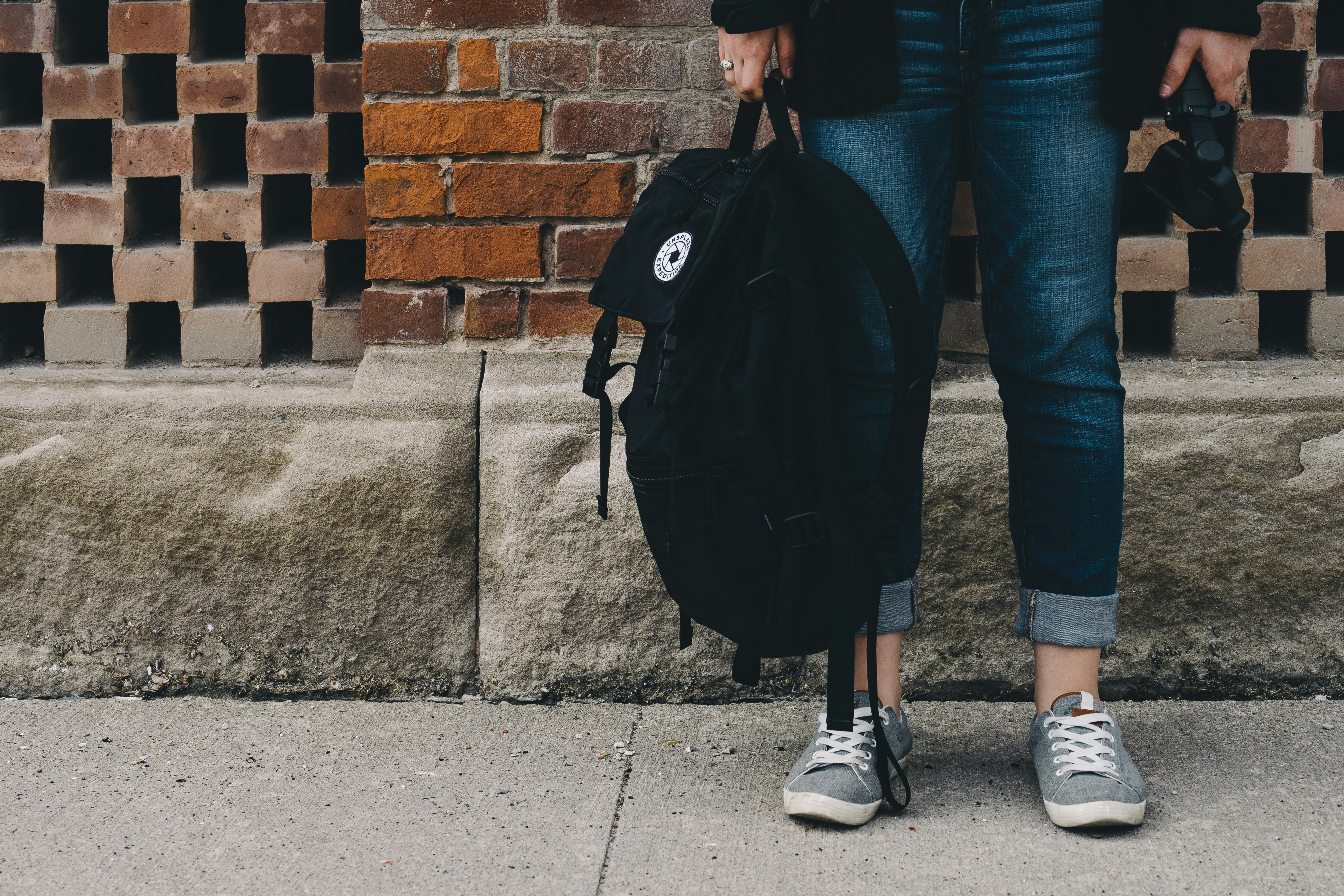 Young teenager with backpack in front of school
