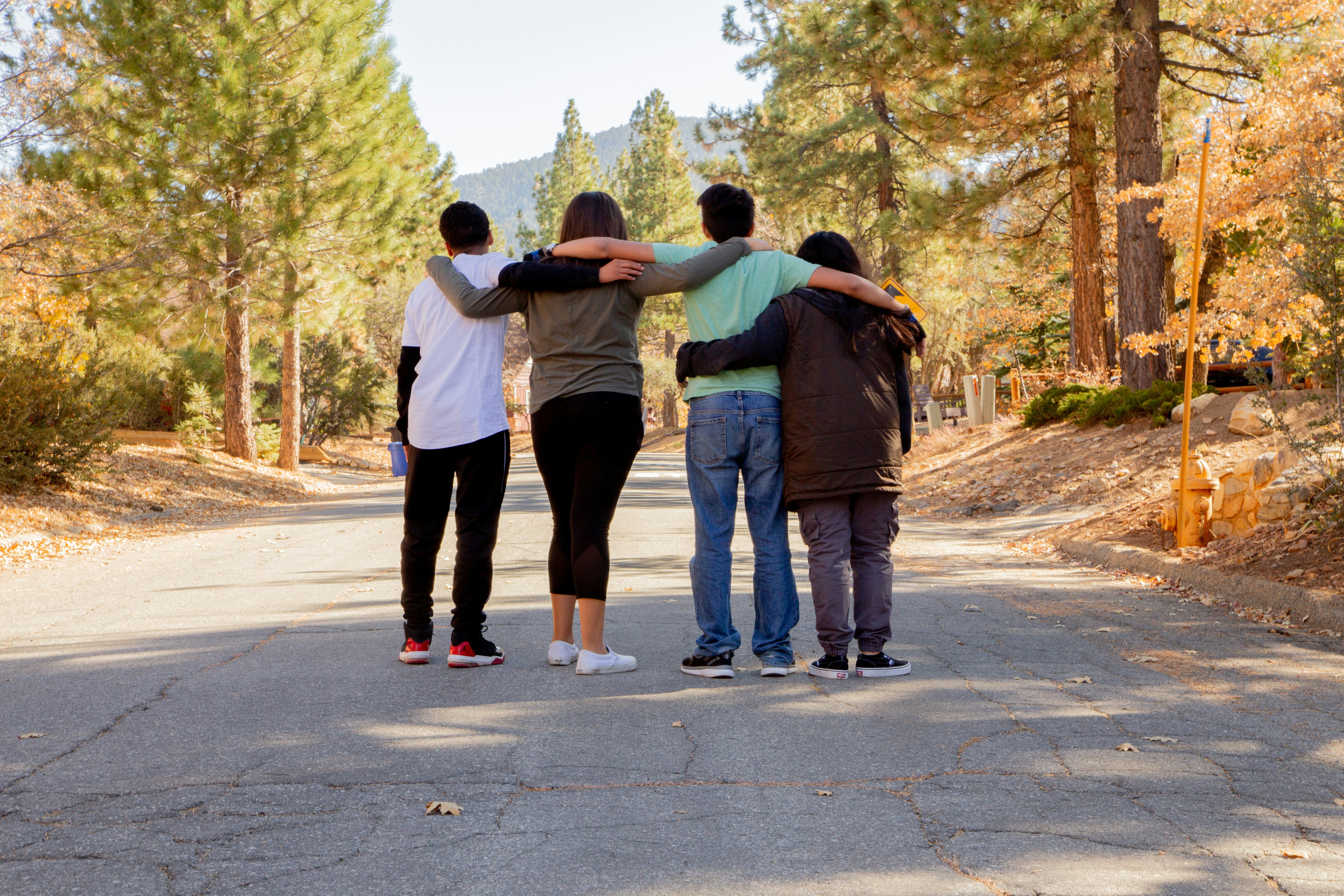 Young teenagers embracing on a wooded trail