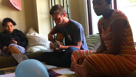 Sarah Nyazungu and Sam Kamminga lead a prayer in friends’s apartment.