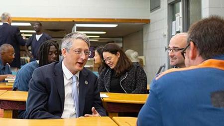 Undersecretary James Kvaal talks with a student and graduate from the Calvin Prison Initiative program during a visit.