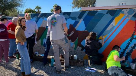 Church and community members participated in painting a mural on a wall of Mission Church in Tucson, Ariz.