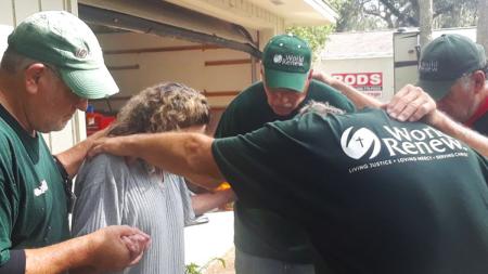 World Renew Disaster Response Services volunteers pray with Tracy outside her Florida home.