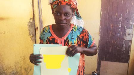 Mrs. Diopp proudly shows off her children's birth certificates.