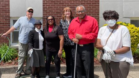 Wayne Coleman (wearing red shirt) with several members of his congregation, planting flowers in front of their church in Paterson, N.J.