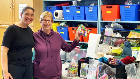 Indigenous Family Centre director Shannon Perez (left) with Marlene Wolters, a member of the Canadian Indigenous Ministries Committee. They show off craft supplies at IFC that will be used for summer programming.