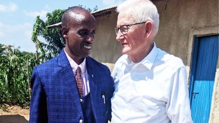 Rev. John Rozeboom (right) stands with a pastor at the refugee camp he visited in Uganda.