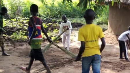 Youth Running club children demonstrating Acts of Love to an elderly home by cleaning the compound