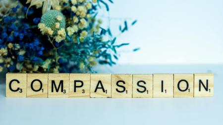 scrabble tiles spell the word compassion