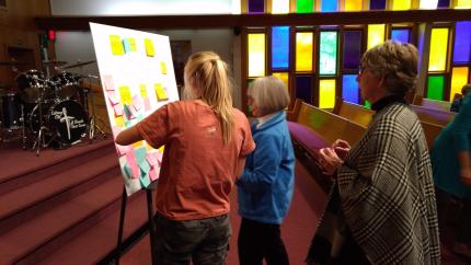 workshop participants put sticky notes on a posterboard