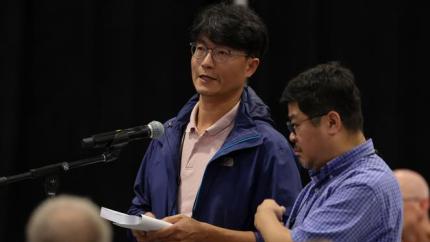 Peter Oh speaking into a microphone