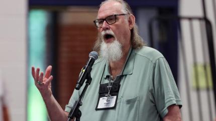 Rod Hugen speaks into a microphone