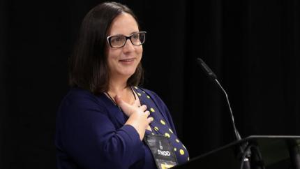 Natasha Klukach speaks into a microphone