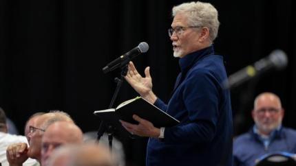 Greg Sinclair speaks into a microphone