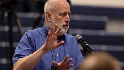 Paul Vanderklay speaks into a microphone at Synod 2025