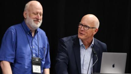 two men sharing a microphone