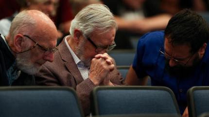 men praying at a worship service