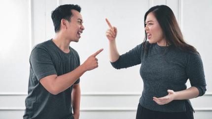 A man and woman pointing fingers at one another