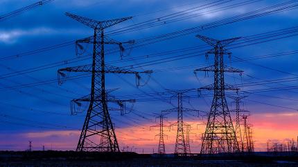 Electricity pylons with a sunset behind them