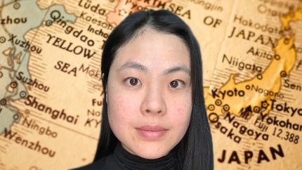 a smiling young woman in front of a map of Japan