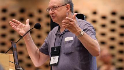 2026 Synod - man behind podium raising hands