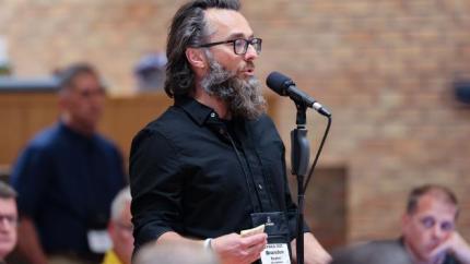 Synod 2026 delegate speaking into microphone
