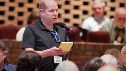 Synod 2026 delegate speaks into a microphone