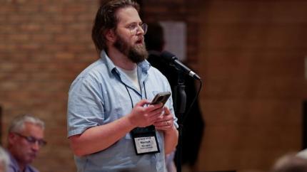 Synod 2026 delegate speaks into a microphone