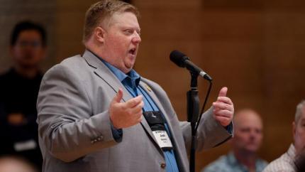 Synod 2026 delegate speaks into a microphone