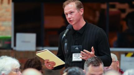 Synod 2026 delegate speaks into a microphone