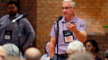 Synod 2026 delegate speaks into a microphone