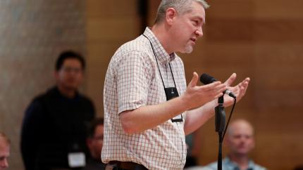 Synod 2026 delegate speaks into a microphone