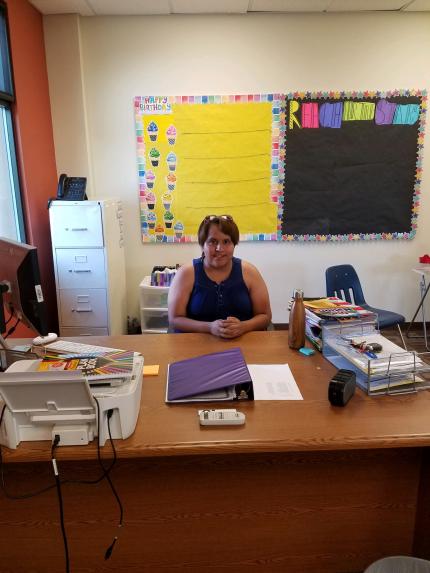 Natasha Natewa sits proudly behind the desk in her third-grade classroom.