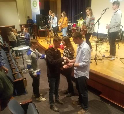 Students at The Well come forward for communion.