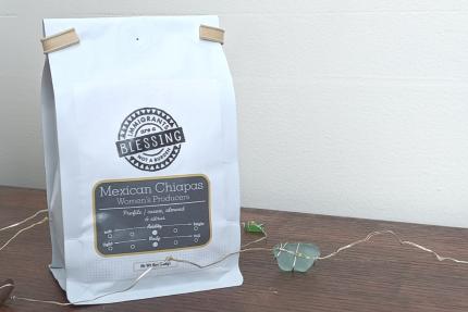 a bag of coffee with the Blessing Not Burden logo on it