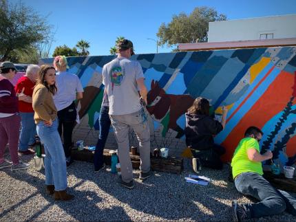 Church and community members participated in painting a mural on a wall of Mission Church in Tucson, Ariz.
