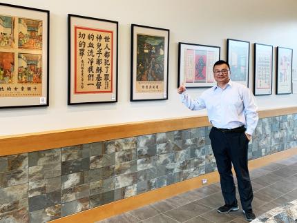 ReFrame’s Chinese ministry leader, Jerry An, with some of the posters currently on display at Wheaton (Ill.) College.