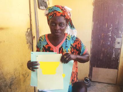 Mrs. Diopp proudly shows off her children's birth certificates.