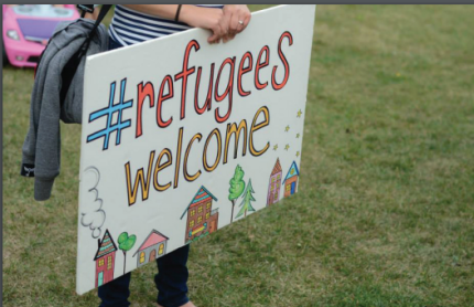 A sign that says Welcome Refugees