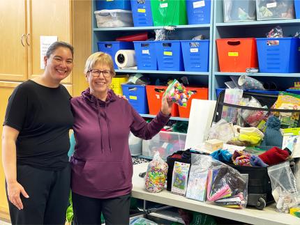 Indigenous Family Centre director Shannon Perez (left) with Marlene Wolters, a member of the Canadian Indigenous Ministries Committee. They show off craft supplies at IFC that will be used for summer programming.