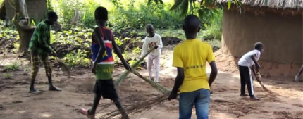 Youth Running club children demonstrating Acts of Love to an elderly home by cleaning the compound