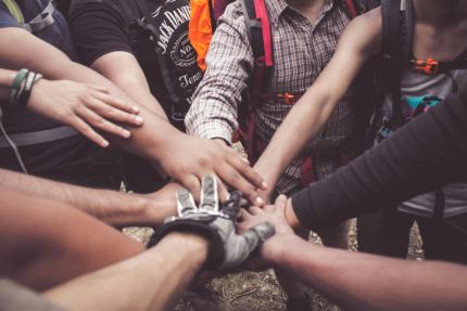 hands meeting in the center of a circle of community activists