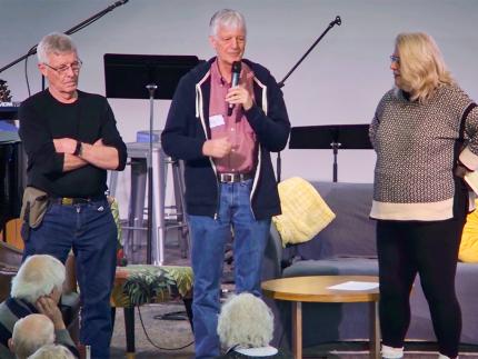 A pulpit supply preaching team of Jim Dekker (left), Syd Hielema (center) and Lesli van Milligen (right) leads a three-person prayer after a congregational meeting.