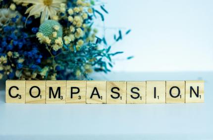 scrabble tiles spell the word compassion