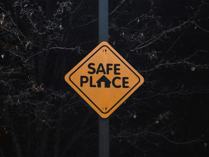 A yellow road side that reads "safe place"