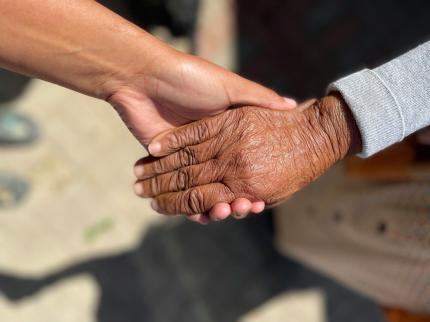 A close up of two hands holding each other.