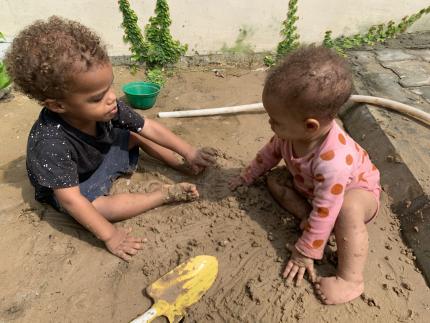 Two toddlers play in the sand