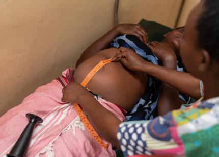 A community health volunteer in Kenya supports an expectant mother. 