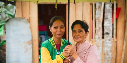 Rochelle Pamen stands under an umbrella with her grandmother Uldarica Miano in the municipality of Dulag on Leyte island. 