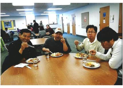 Young men eat Korean-style food after services at Holland Korean Church.