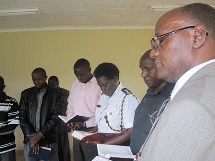 Wa Kitavi (right) prays with others in Kenya.